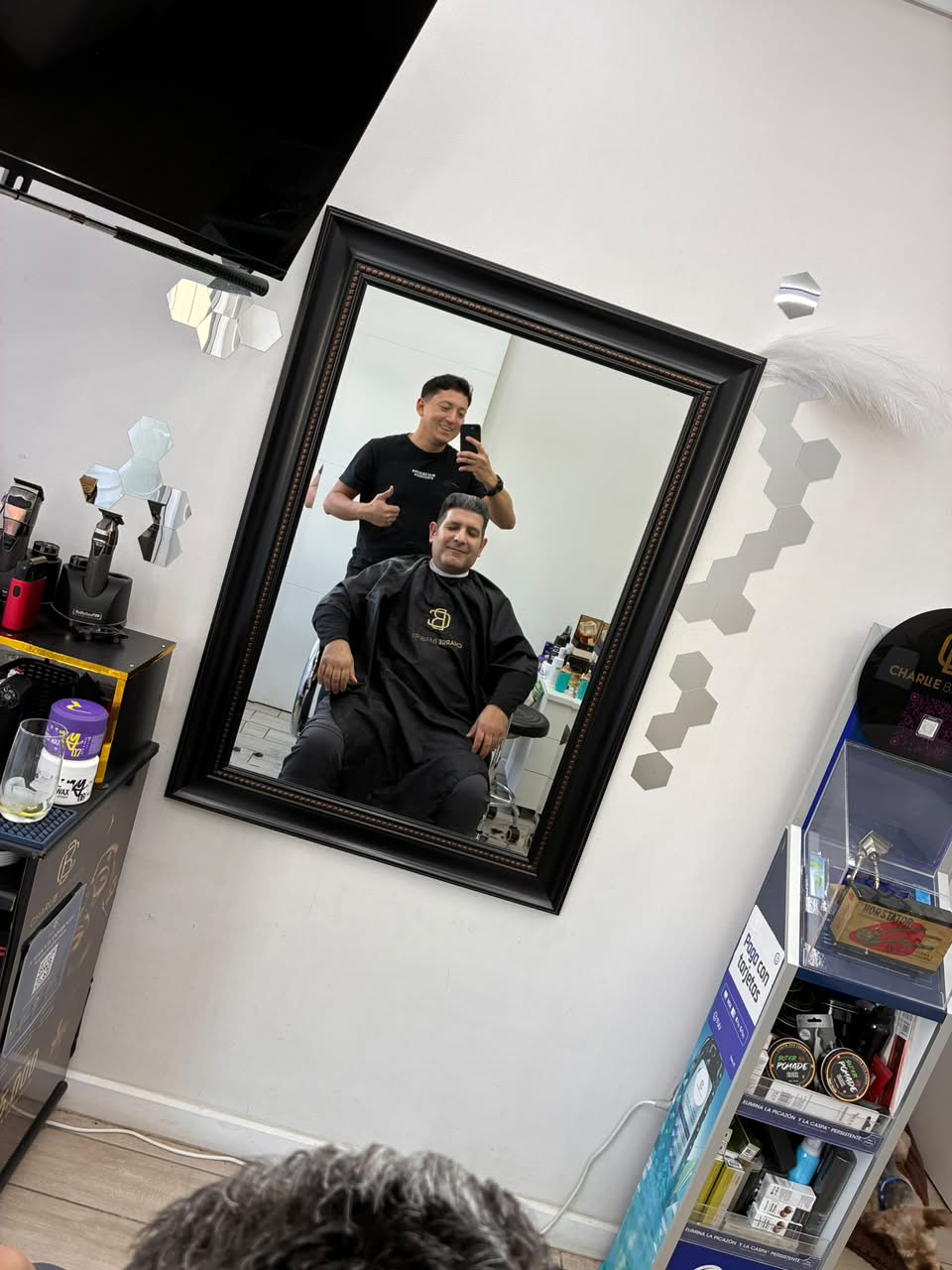Momento de Charlie junto a un cliente en la barbería, fotografía 2